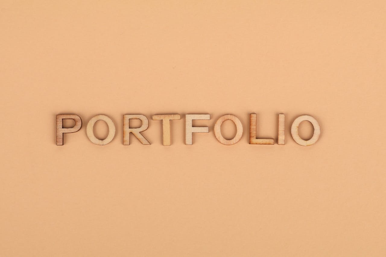 Close-up of wooden letters spelling PORTFOLIO on a yellow background, offering creative copyspace.